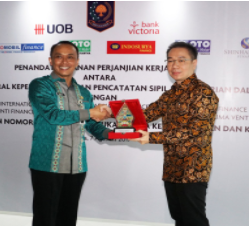 Penyerahan plakat oleh Zudan Arif Fakrulloh, Dirjen Dukcapil kepada Gunawan Effendi, CEO IMFI